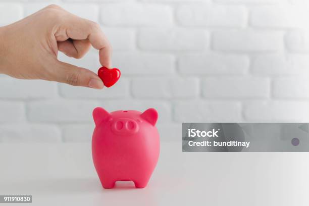Mans Hand Putting Red Heart In To Piggy Bank Metaphor Saving Love For Lover Or Family In Every Dayconcept Of Happy Relationship Stock Photo - Download Image Now