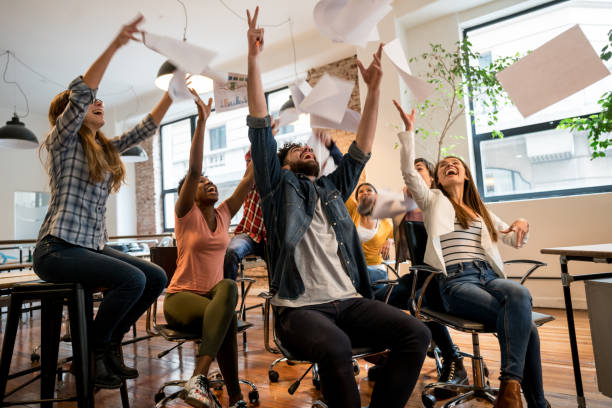 istock People celebrating at the office throwing papers in the air 911928636