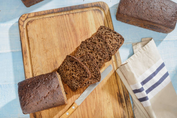 istock Sliced rye bread on wooden blue surface, top view 911933646