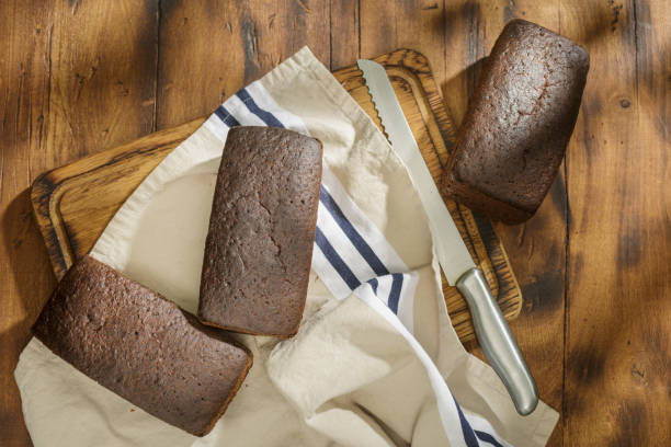istock Three loaf of rye bread on a dark surface, top view 911933894