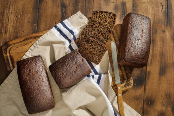 istock Top view chopped loaf of rye bread on dark surface, top view 911933896