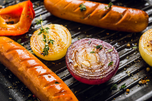 Grilles sausages with onion, garlic and spices on the pan