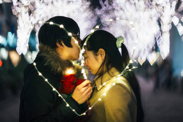 A young Japanese couple is having a romantic time in the street in Tokyo.