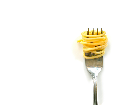 Cooked capellini spaghetti with fork isolated on white background. Copy space.