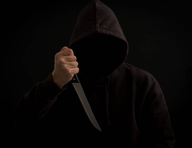 istock A killer with a knife in his hand in the dark 911941412