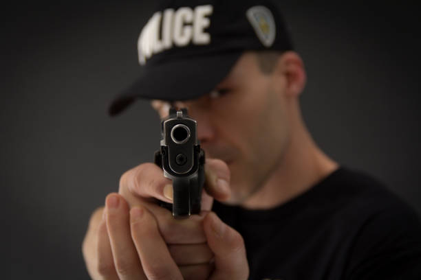 полицейский с пистолетом в руке - weapon gun order handgun стоковые фото и изображения