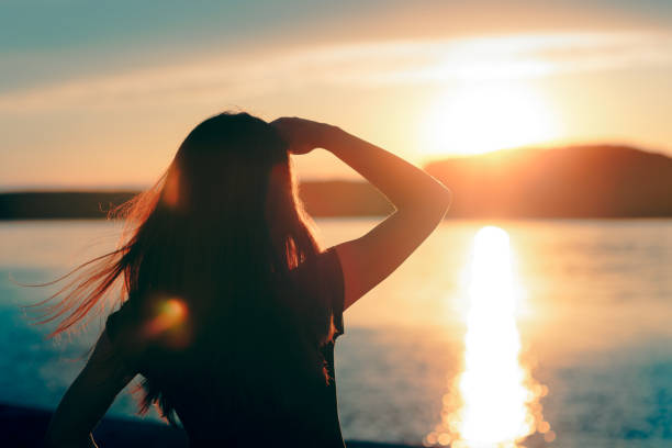 海で夕日を見て幸せな希望に満ちた女 - 目線 ストックフォトと画像