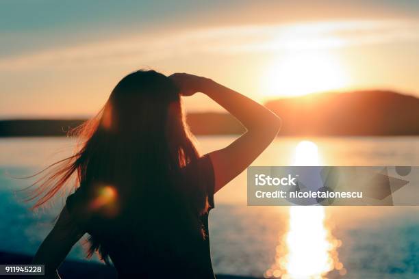 Happy Hopeful Woman Looking At The Sunset By The Sea Stock Photo - Download Image Now