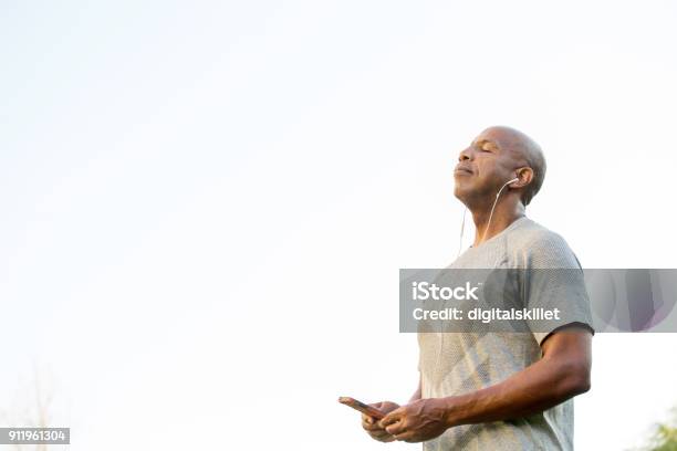 Fit African American Man Listening To Music Stock Photo - Download Image Now - 55-59 Years, Active Lifestyle, Active Seniors