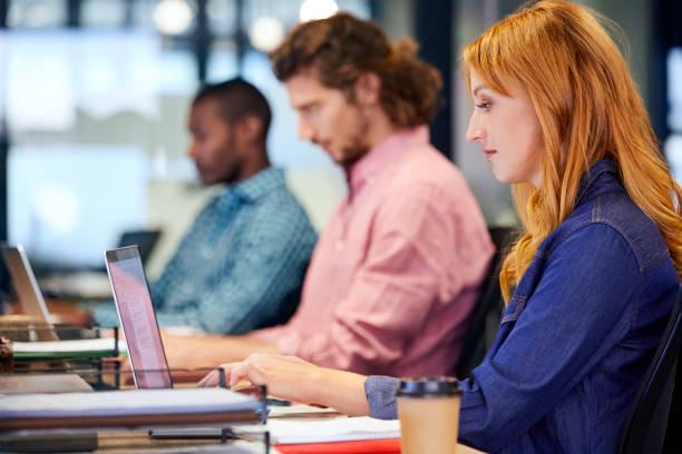 istock Smiling businesswoman with colleagues using laptop 911963958
