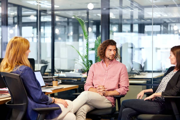 istock Business people in meeting while sitting on chairs 911964026