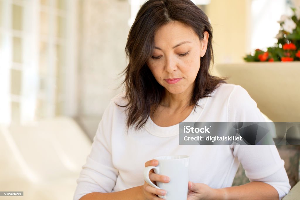 Concrened woman looking worried. Concrened woman looking worried and praying on a sofa. Women Stock Photo