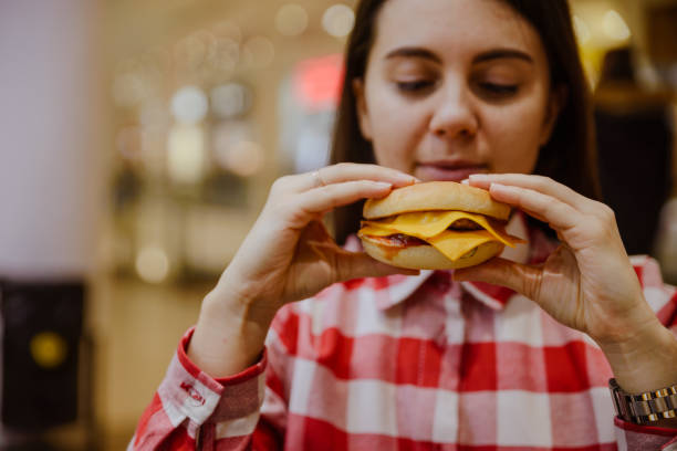 istock woman eat cheeseburger 911967856