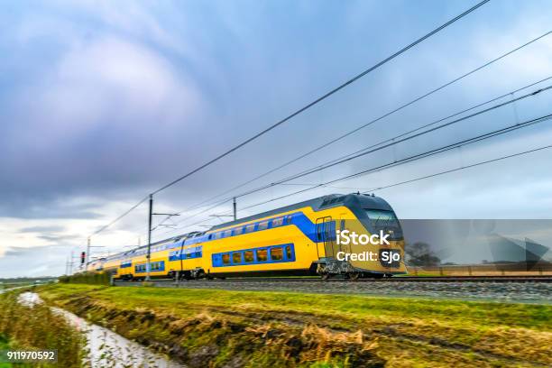 Train Driving In A Rural Landscape During A Dark Day Stock Photo - Download Image Now