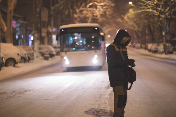 istock Man walking on snowy street at night 911970982