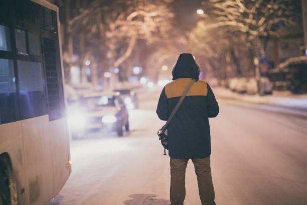 istock Man walking on snowy street at night 911971254