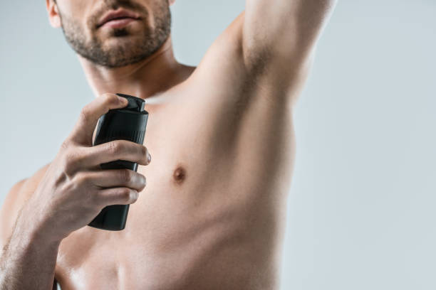 istock shirtless man spraying deodorant 911975550