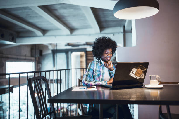 istock Young woman, African-American Ethnicity, working in cafe, using laptop. 911978012