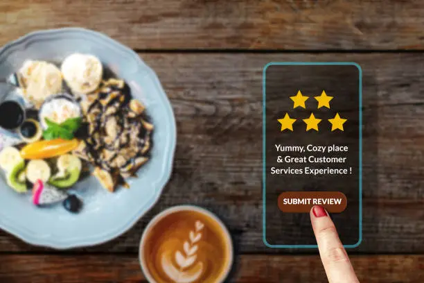 Photo of Customer Experience Concept. Woman using Smartphone in Cafe or Restaurant to Review Feedback Five Star Rating in Online Satisfaction Survey Application, Top View