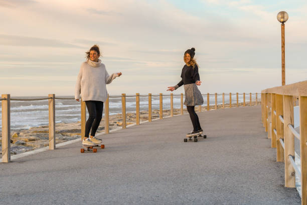 istock Two female friends playing with skateboard 911978696