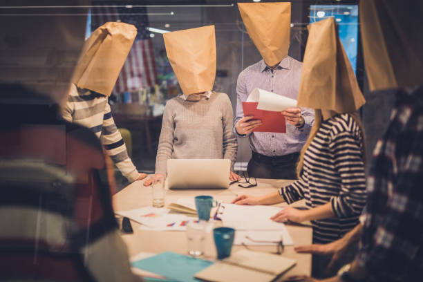 gruppe von geschäftsleuten mit papiertüten mit einem treffen im büro. - obscured face fotos stock-fotos und bilder