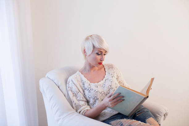 istock blonde girl reading a book is preparing 911979522