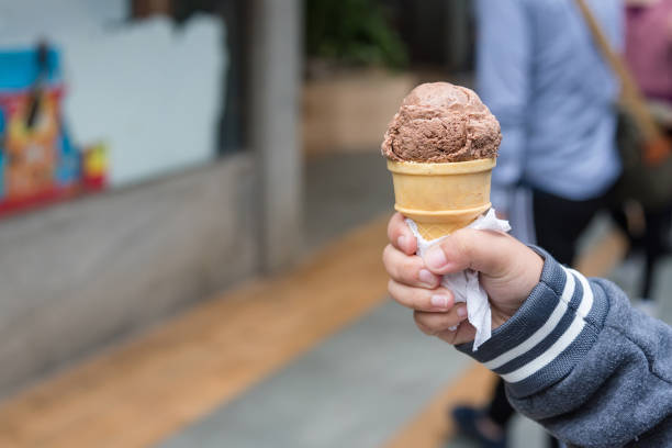 istock Hand holding ice cream cone on nature background. 911982714