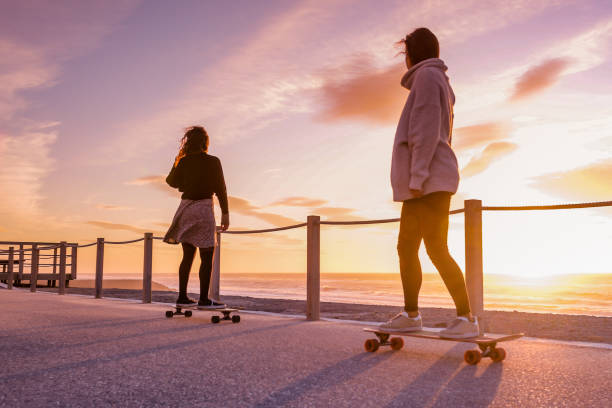istock Two female friends playing with skateboard 911982750