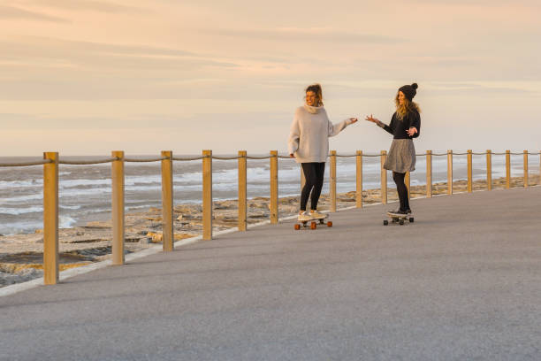 istock Two female friends playing with skateboard 911982832