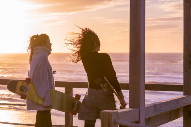 istock Two female friends chatting with skateboard 911983246