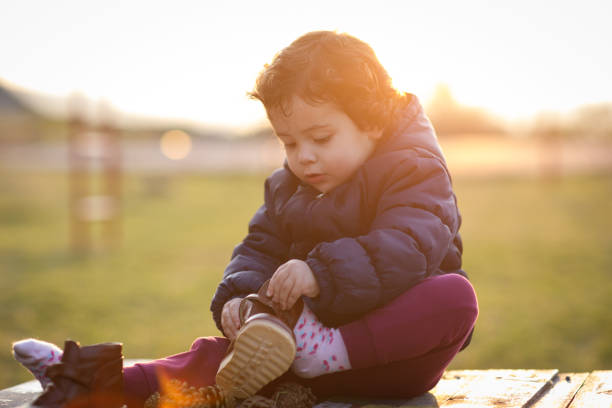 istock Little girl putting on her shoe 911994698