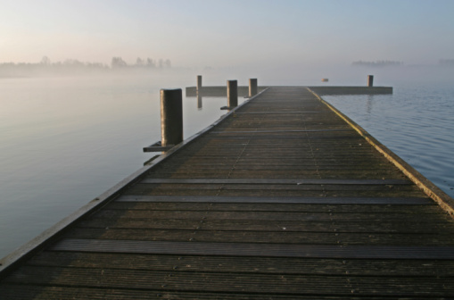 Lake and pier in the early morning mist.