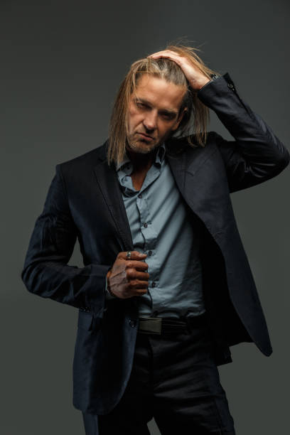 istock Long hair man in suit possing. 911996390