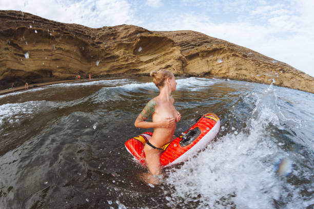 chica joven topless en tangas en el flotador de piscina de olas del mar - shirtless jeans women blond hair fotografías e imágenes de stock