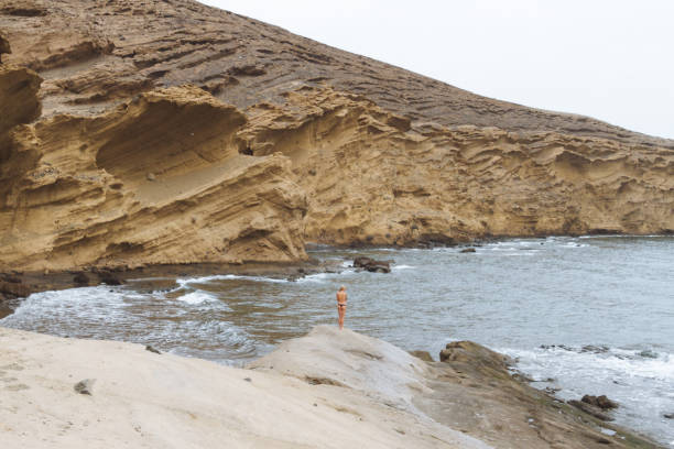 joven rubia en tangas posando en la playa de arena en el desierto - shirtless jeans women blond hair fotografías e imágenes de stock