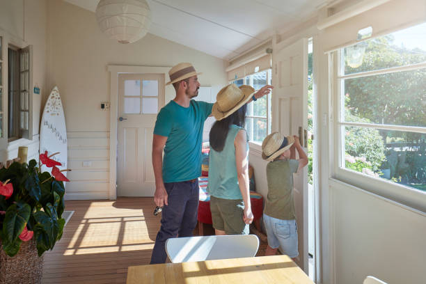 Family wearing straw hats standing in house Father and mother with son opening door. Family is wearing straw hats and casuals. They are standing in house on sunny day. straw hat photos stock pictures, royalty-free photos & images