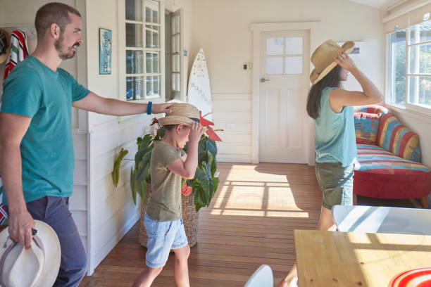 Family wearing straw hats while walking in house Parents walking with son while wearing straw hats. Family is in casuals. They are at house on sunny day. chaise longue photos stock pictures, royalty-free photos & images