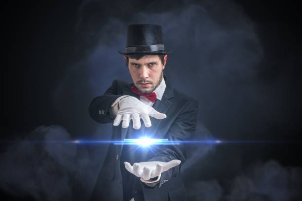 istock Young magician man is showing bright ball that levitates. Black background. 912000812