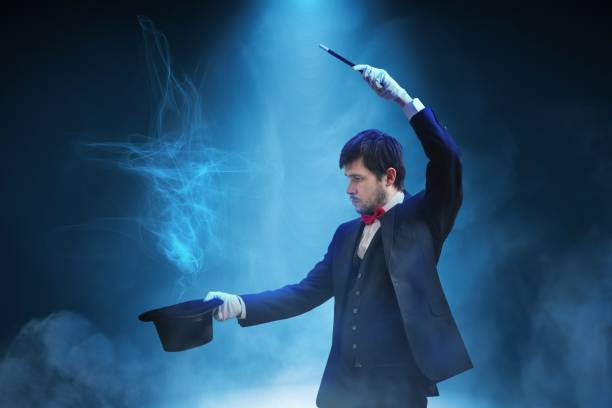 istock Magician or illusionist is showing magic trick. Blue stage light in background. 912000890