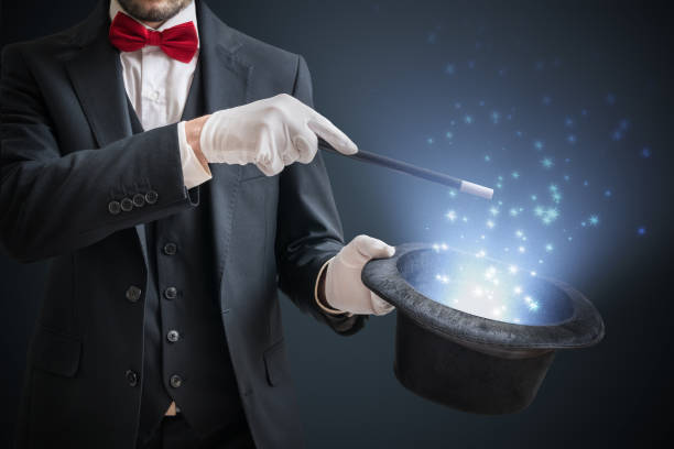 magik lub iluzjonista pokazuje magiczną sztuczkę. niebieskie światło sceniczne w tle. - magician magic trick hat magic wand zdjęcia i obrazy z banku zdjęć