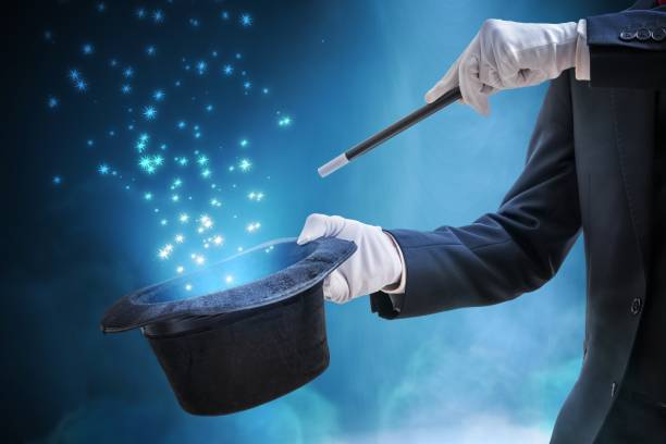 istock Magician or illusionist is showing magic trick. Blue stage light in background. 912003066