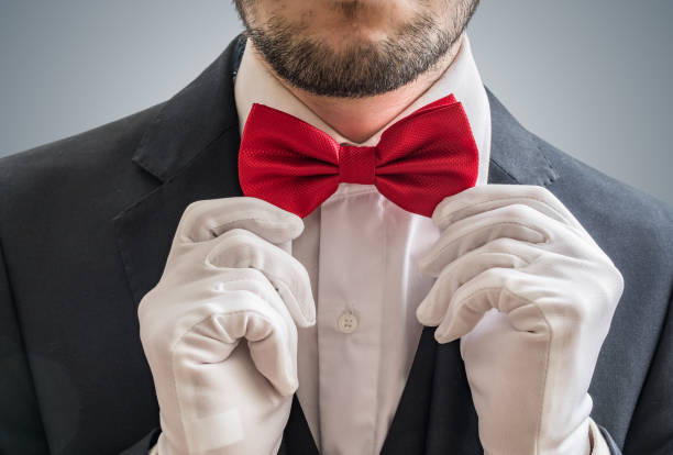 istock Actor or illusionist in white gloves is taking a red bowtie. 912003126
