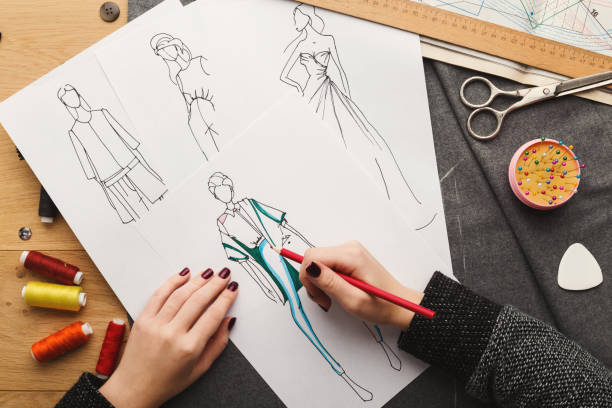 istock Top view on woman designer drawing clothes sketches 912003550