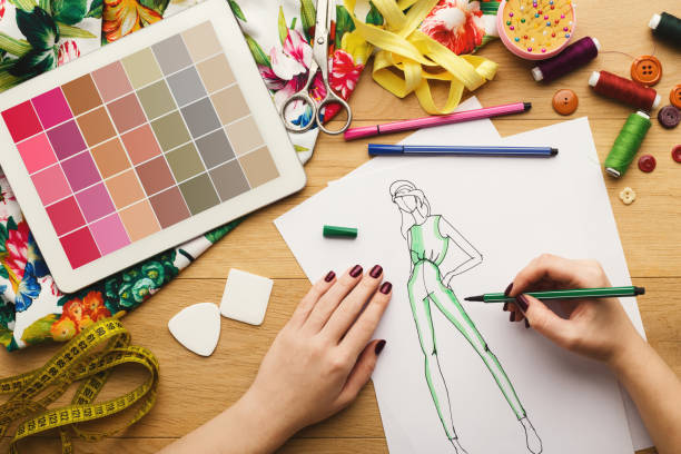 istock Top view on woman designer drawing clothes sketches 912004196