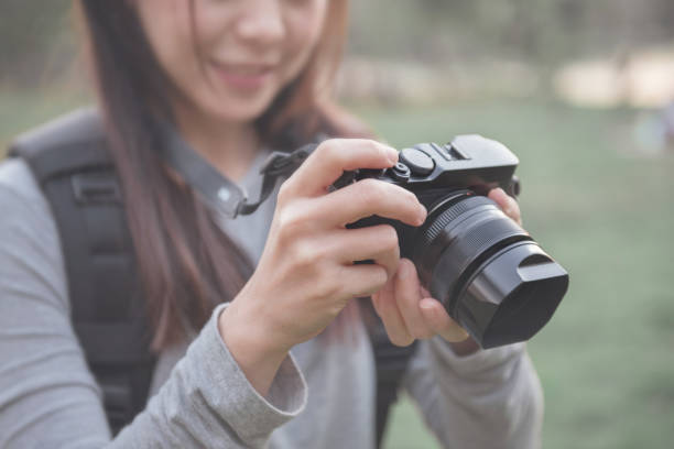 istock traveler hold mirrorless camera in his hands with blurred nature background, copy space 912004644