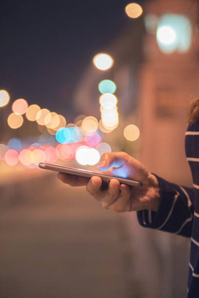 istock Woman using Mobile smartphone in the street, night light bokeh Background, 912004646