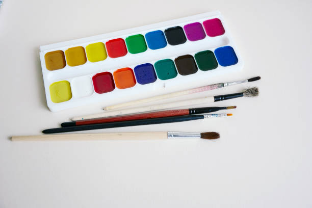 istock Paint brushes and a set of paints on a white paper 912007528