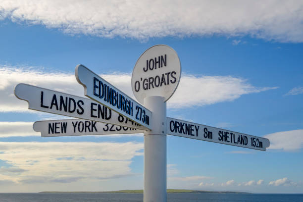 distancia de señal en el pequeño pueblo costero de john o'groats, situado en las highlands escocesas y en el punto más septentrional de gran bretaña del continente. - directional sign crossroads sign distance sign sign fotografías e imágenes de stock