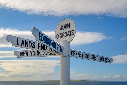 Distance sign at the small coastal village of John O'Groats, located in the Scottish Highlands and in the most northerly point of mainland Britain.
