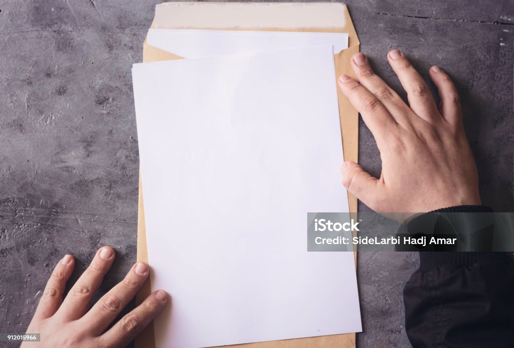 Hand opening brown Document Envelope with copy space Envelope Stock Photo